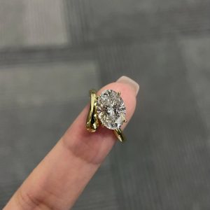 Oval solitaire engagement ring with a bypass shank and four-prong setting