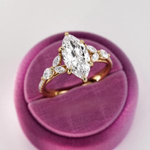 Marquise diamond engagement ring with pavé shank and accent marquise and round stones