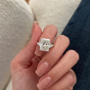 Radiant-cut three stone engagement ring with trillion side diamonds on polished band