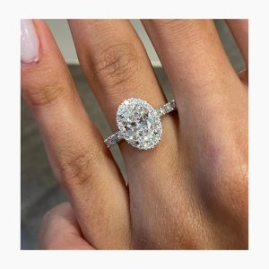 Oval halo engagement ring with baguette side diamonds and pavé accents on a straight shank