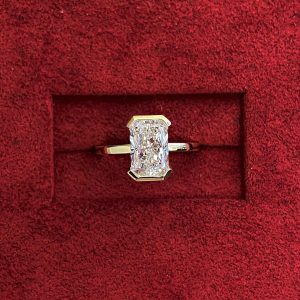 Bezel-set rectangular solitaire engagement ring with a polished flat band
